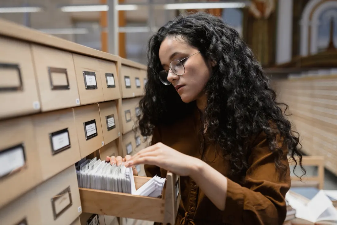 A researcher looking through a library card catalogue